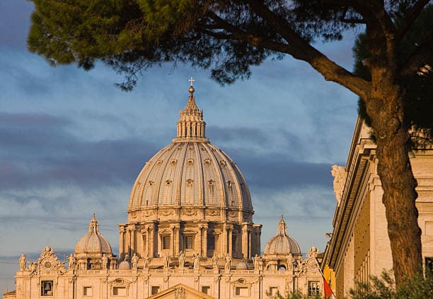 Iconic view of the St. Peter's Basilica dome at sunset.