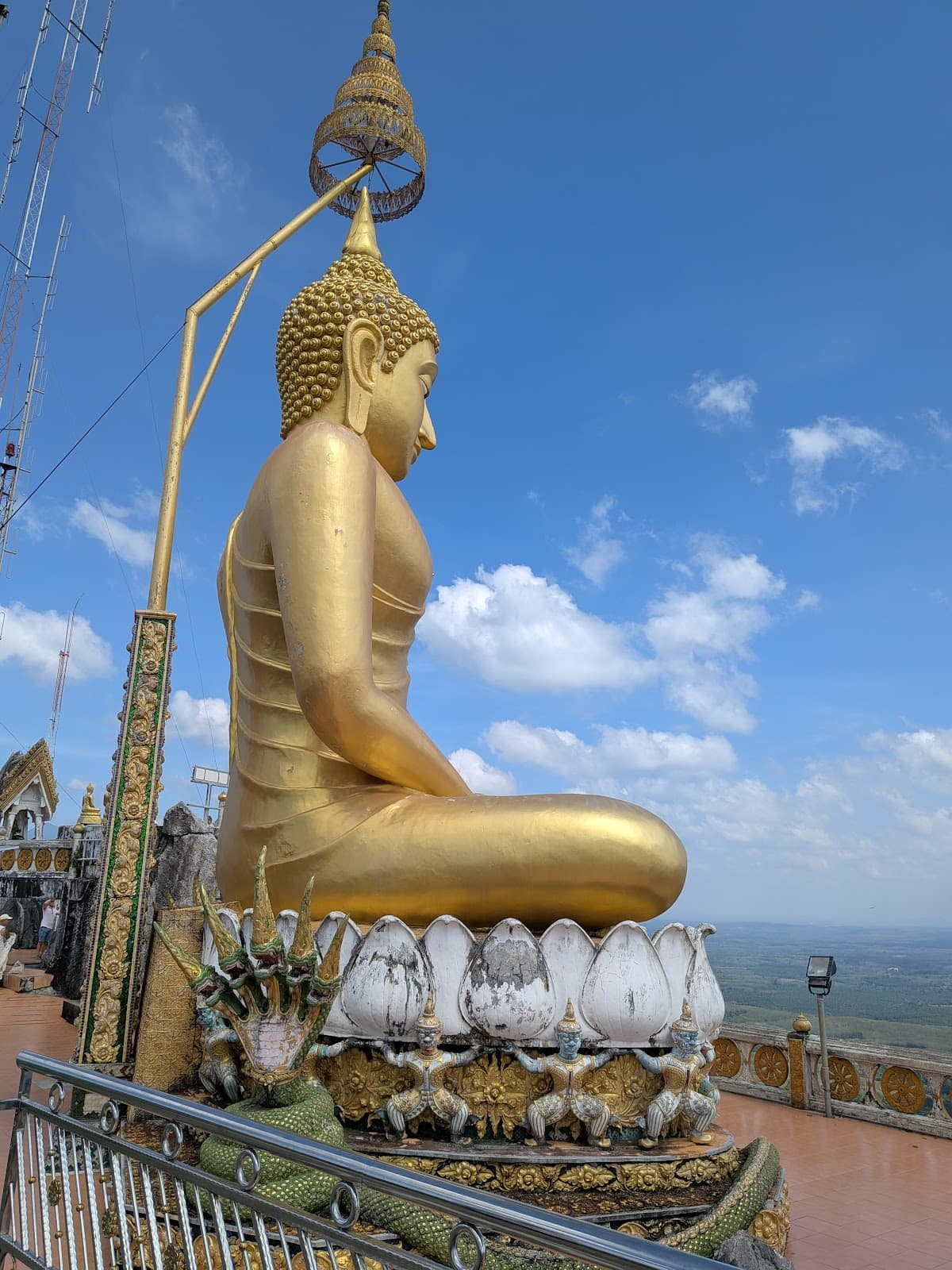 Iconic golden Buddha statue at the summit of Tiger Cave Temple.