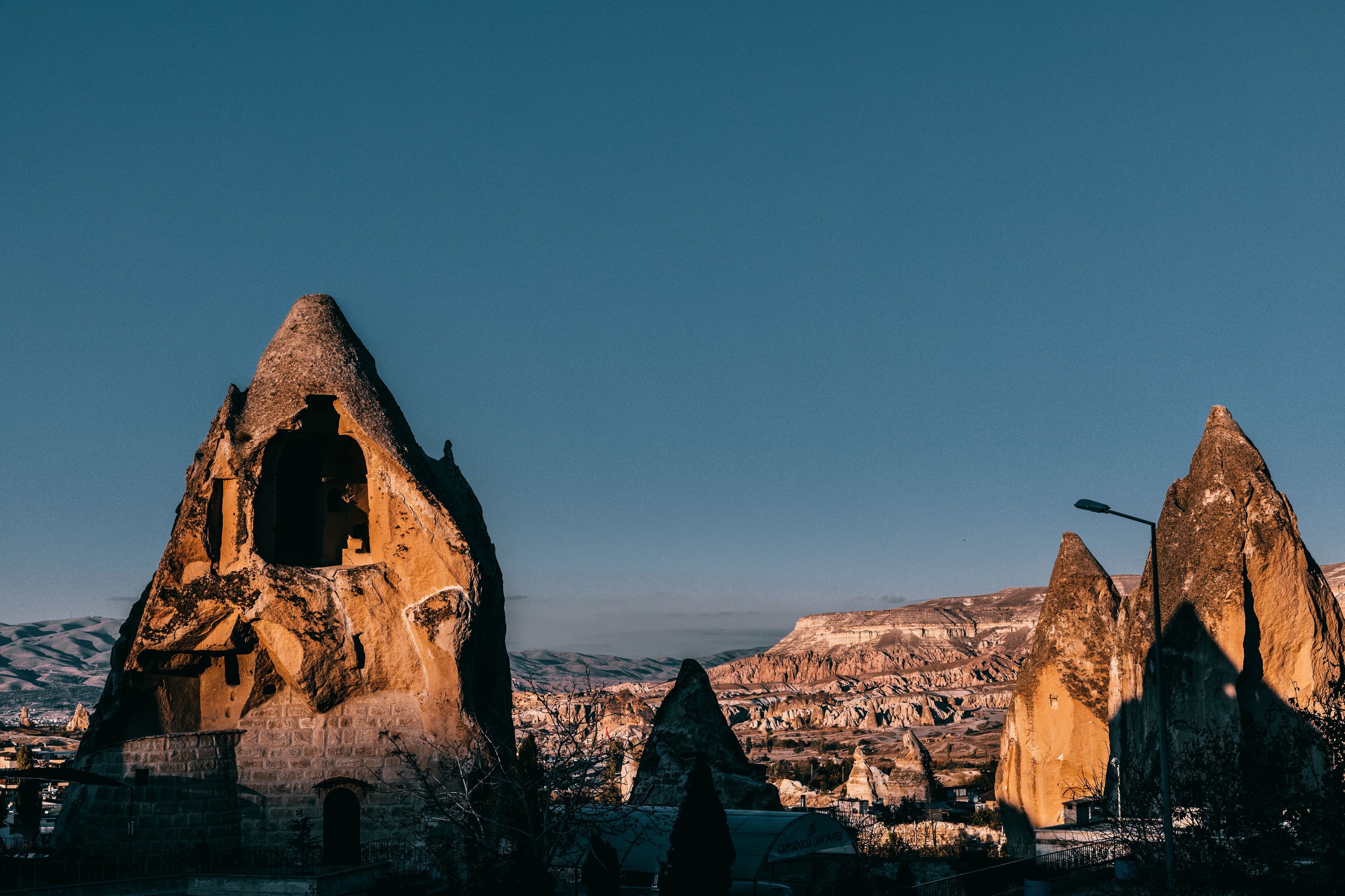 ضوء الساعة الذهبية يضيء مداخن الجنيات القديمة والمساكن الكهفية في منتزه غوريم الوطني في كابادوكيا.